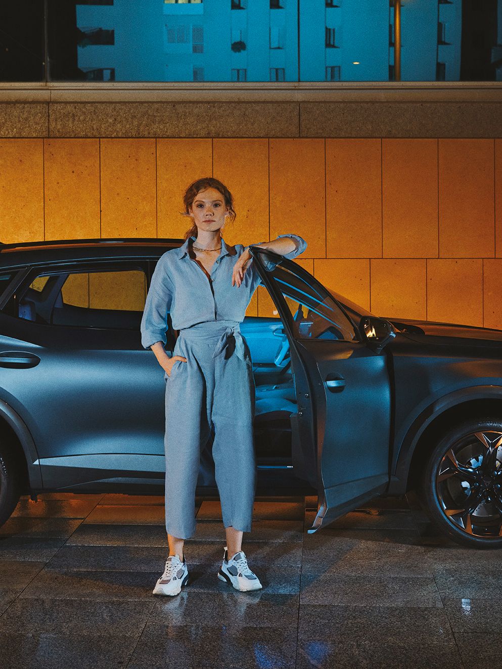 CUPRA Formentor bei Nacht, eine Frau steht davor