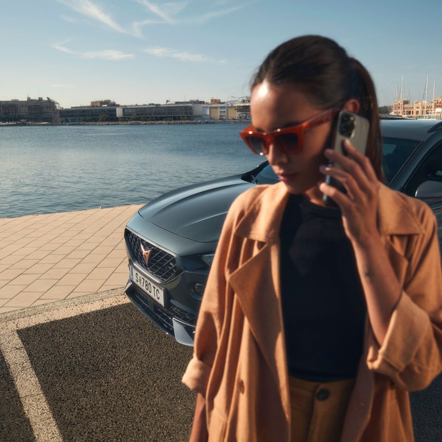 Eine Frau telefoniert vor einem CUPRA Formentor