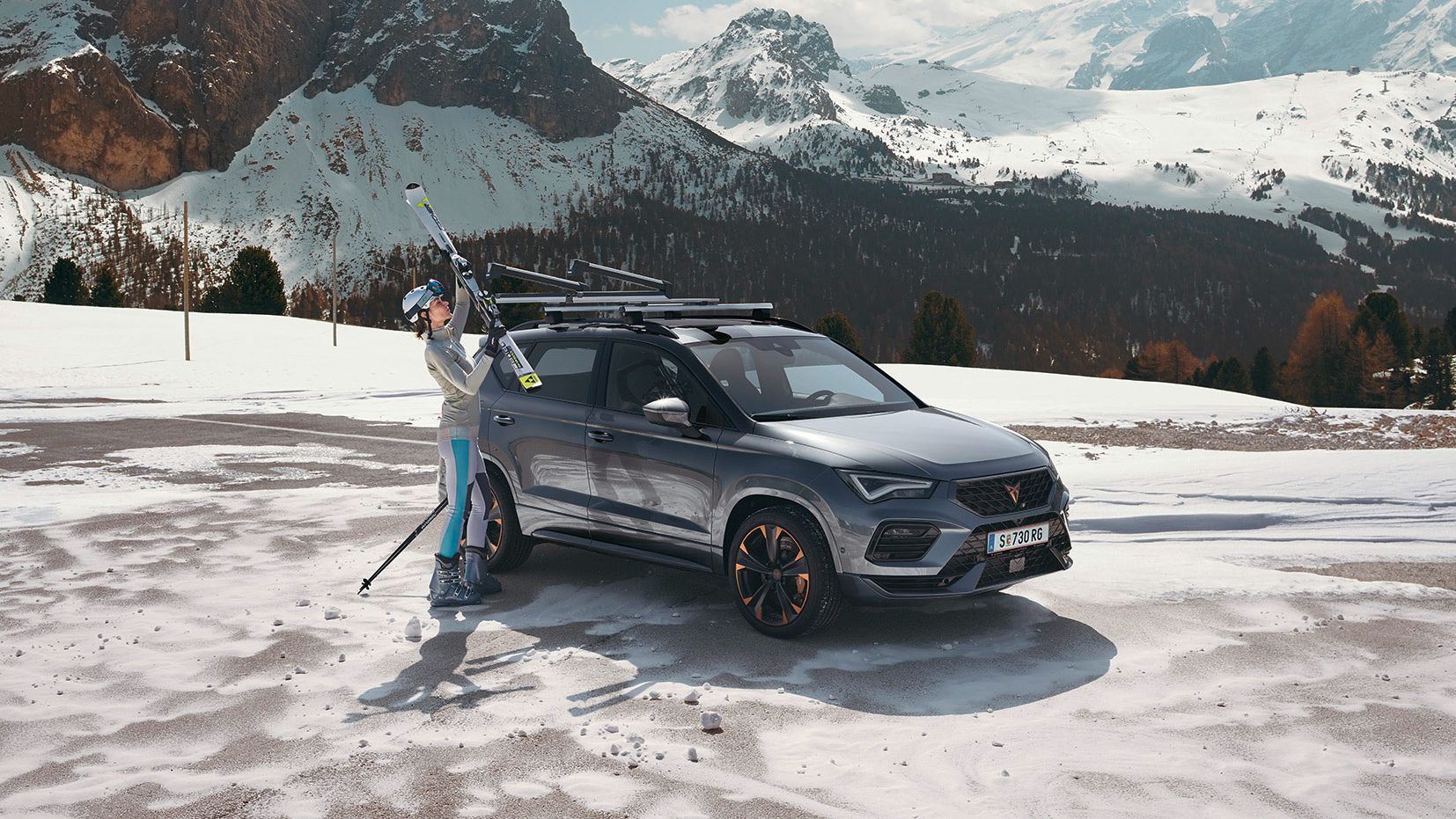 Eine Frau befestigt ihre Ski am Skiträger eines CUPRA Ateca