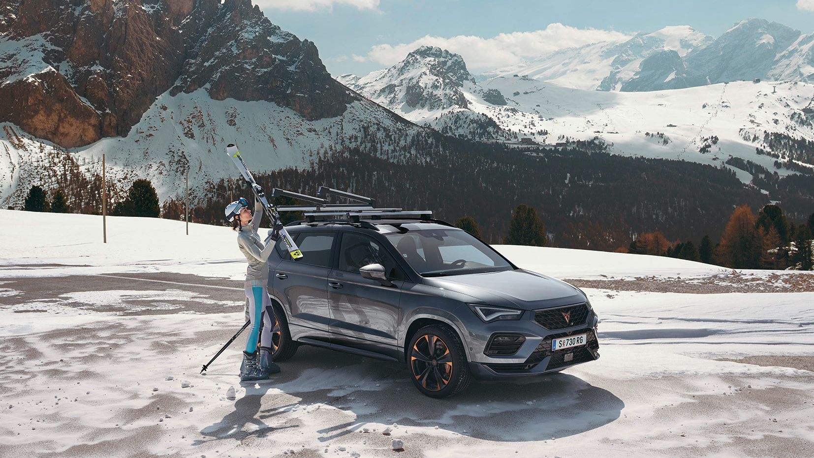 Eine Frau befestigt ihre Ski am Skiträger eines CUPRA Ateca