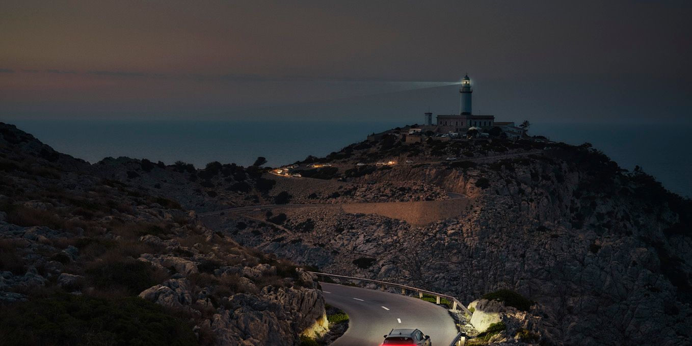 Ein CUPRA Formentor bei Nacht auf einer gebirgigen Küstenstraße