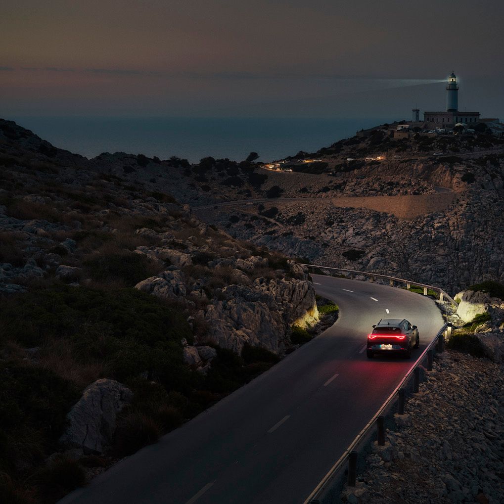 Ein CUPRA Formentor bei Nacht auf einer gebirgigen Küstenstraße